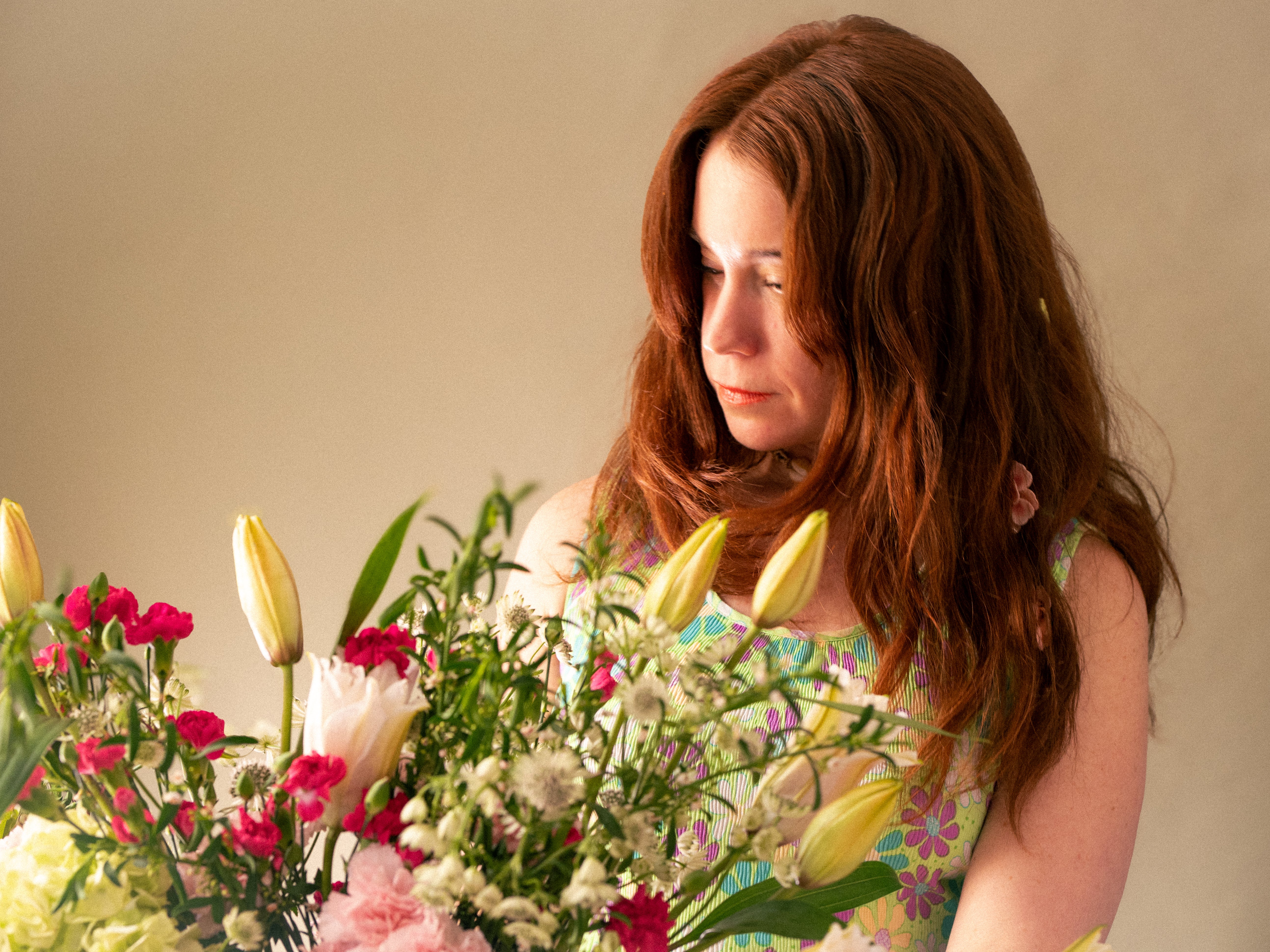 Woman holding a bouquet of flowers with a neutral background